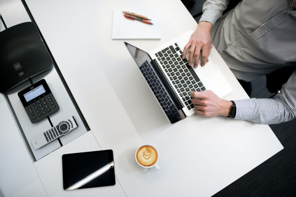 white table man laptop cup of coffee